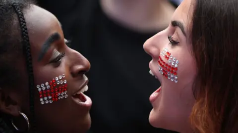 Action Images/Reuters Two girls with the England flag in sequins on their cheeks look at each other