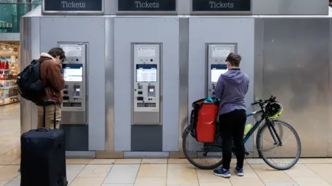 Getty Images People buying rail tickets