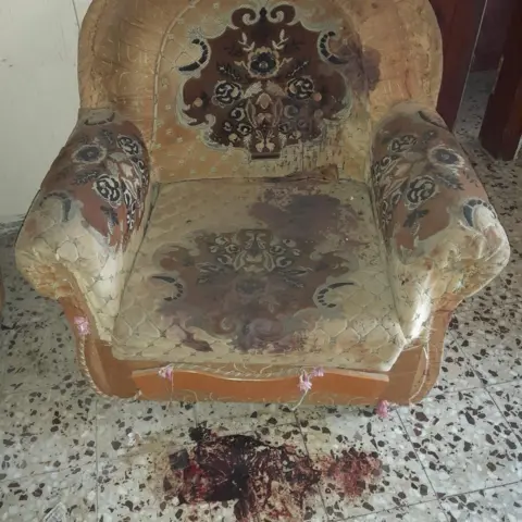 Family handout Armchair with blood stains and blood on the floor beneath it