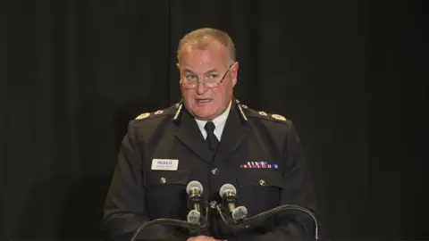 Greater Manchester Police chief constable Stephen Watson, in full uniform, speaks from the podium at the press conference launching the Baird inquiry