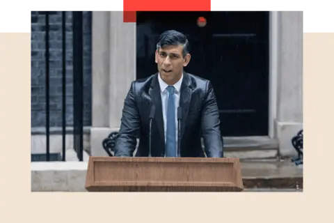 Getty Images Rishi Sunak speaking at a lectern in a drenched suit in front of number 10 Downing Street