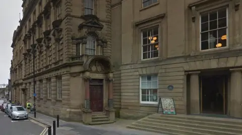 Google The door to Bolbec Hall, which is has an arched entrance way supported by two pillars. A sign for The Lit and Phil is standing outside the neighbouring building