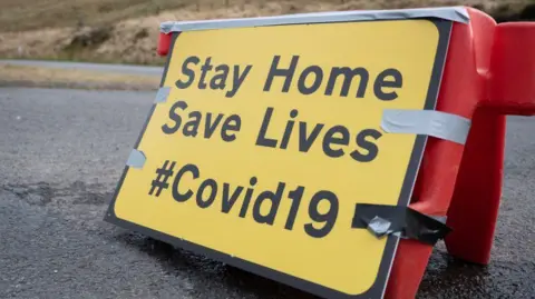 Getty Images A sign warning the public to stay at home during the Covid pandemic