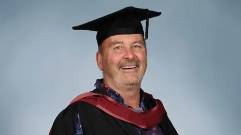 University of Bristol/PA Media Jonny Clothier, wearing a graduation cap and gown