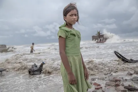 Supratim Bhattacharjee A girl stands in front of her tea shop, which has been destroyed by the sea during a storm, in Frazerganj, Sundarbans, India