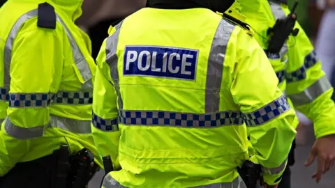 Alamy Stock photo of a group of police officers in high visibility jackets 