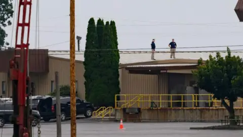 Getty Images Investigators on the roof of the building where the attack was launched from