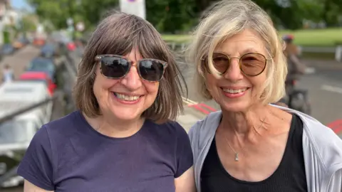 Pauline Taylor with her friend grinning after seeing Banksy