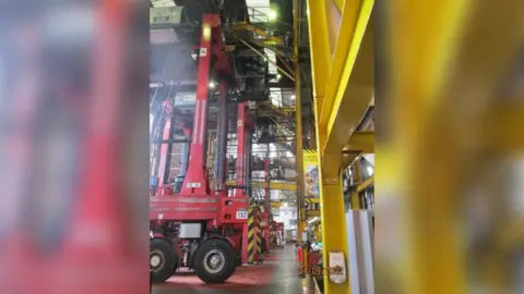 Health and Safety Executive A straddle carrier parked inside a warehouse, showing the distance Mr Hooper fell