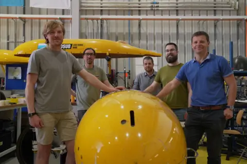 Gwyndaf Hughes/BBC Team of engineers at the National Oceanography Centre with Boaty McBoatface robot