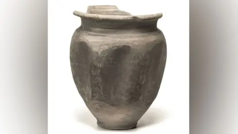 Oxford Archaeology A nearly intact Roman beer beaker with a narrow base and a wider middle, narrowing to a slightly smaller rim