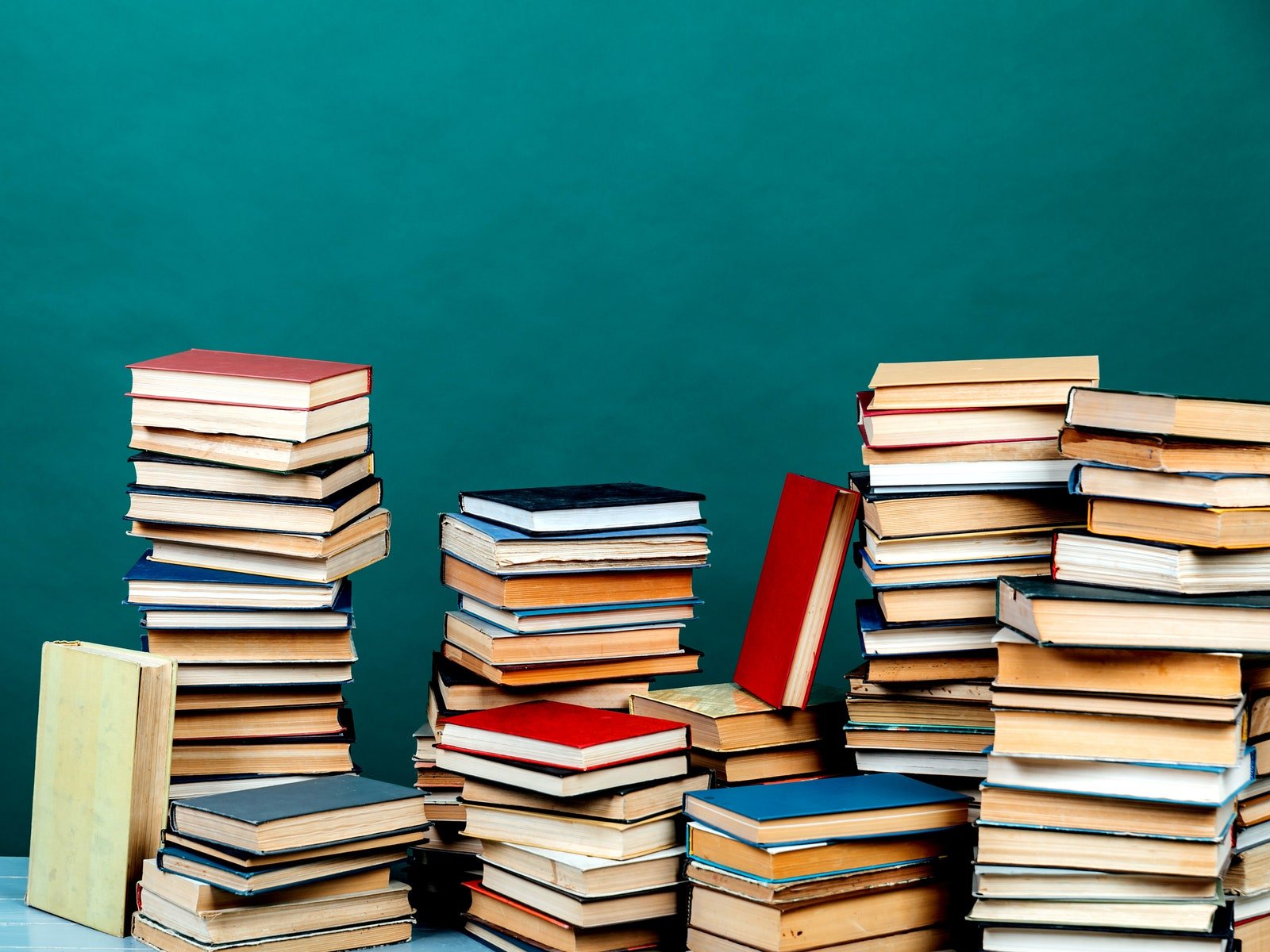 Stacks of used books on a green backdrop