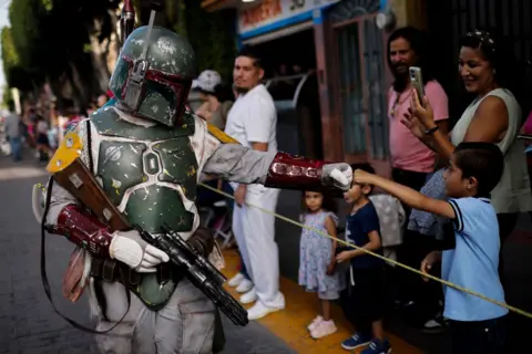 Rodrigo Oropeza / AFP A Star Wars fan dressed as Boba Fett takes part in a parade