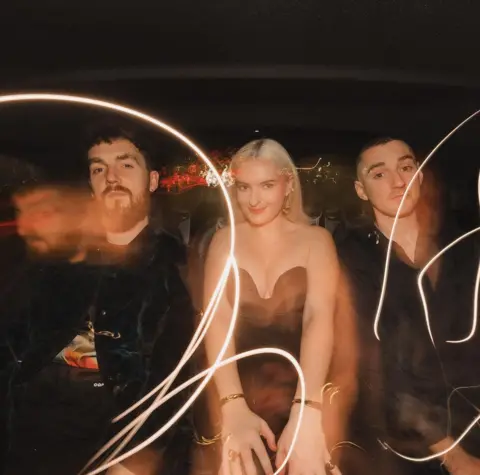 Clean Bandit / Instagram Shot of Clean Bandit in the back of a car, illuminated by flashes of light