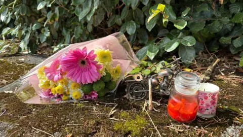 Flowers and candles outside property on Hereford Close