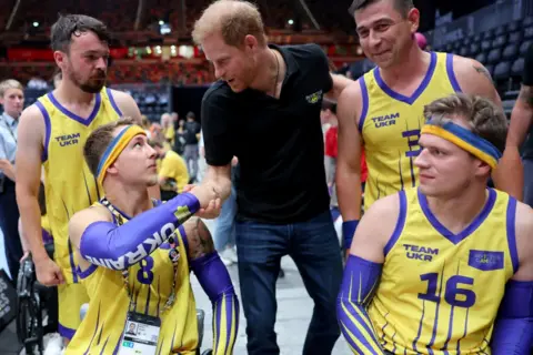 Getty Images A man in a wheelchair shakes Prince Harry's hand