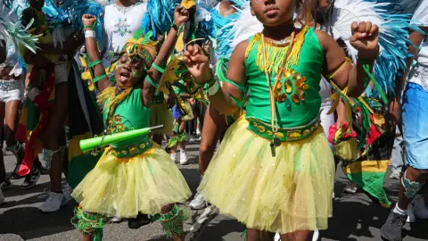 PA Media Two girls dancing in yellow tutu skirts and green vest tops