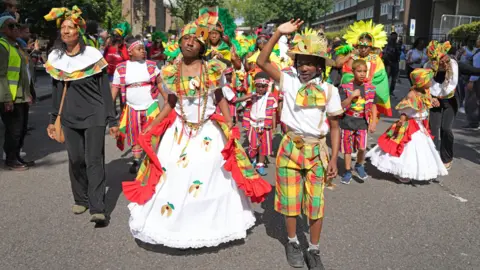 PA Media Children in costume join the parade