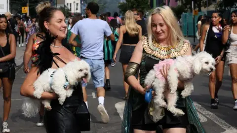 Reuters Two women with their dogs at the Notting Hill Carnival in west London