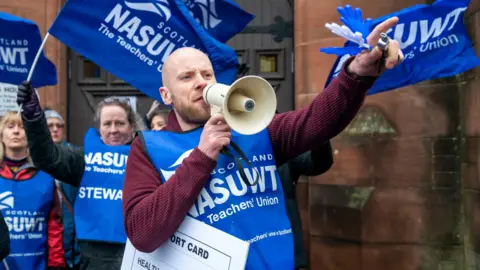 PA Media Members of the NASUWT union on a picket line in 2023