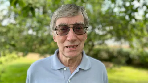 BBC Phil Emmett, a man with grey hair wearing sunglasses, in his garden