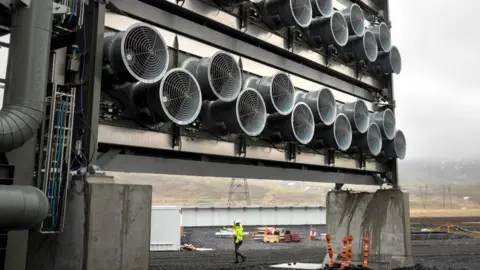 Getty Images A bank of fans draws air through specialized filters at Climeworks' Mammoth carbon removal plant