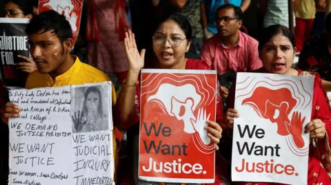 Reuters A group of protesters hold up signs demanding justice