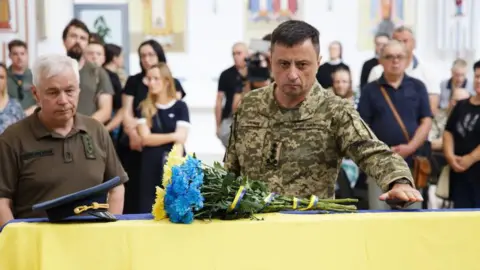 Getty Images Lt Gen Mykola Oleshchuk pays his respect to an F-16 pilot killed in action 