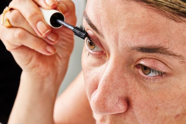 Closeup of a person applying ILIA Limitless Lash Lengthening Clean Mascara