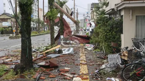 Reuters Debris and objects blown by strong winds on a road in Miyazaki, south-west Japan, 29 August 2024. 