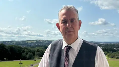 BBC Edwin Poots in white shirt with grey waistcoast and tie