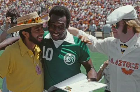 Getty Images Sérgio Mendes, along with Pelé and Elton John, attend a match by the LA Aztecs in Los Angeles, 1977