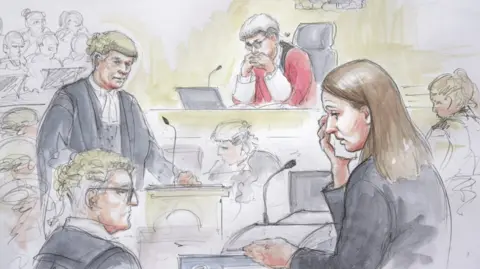 Helen Tipper A sketch of Lucy Letby appearing on trial at Manchester Crown Court, surrounded by legal counsel