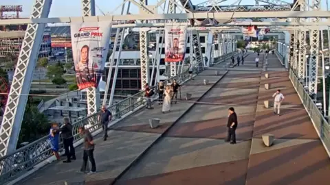 Metropolitan Nashville Police Department Footage released by the Metropolitan Nashville Police Department shows Jon Bon Jovi on the John Seigenthaler Pedestrian Bridge in Nashville with his arms on a woman wearing a blue dress who he had managed to persuade to come off of a bridge ledge. Other people can be seen around the two.