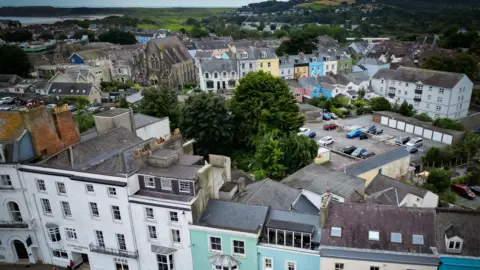 BBC Aerial shot of Tenby showing the town's colourful terraced housing the and sea in the  distance